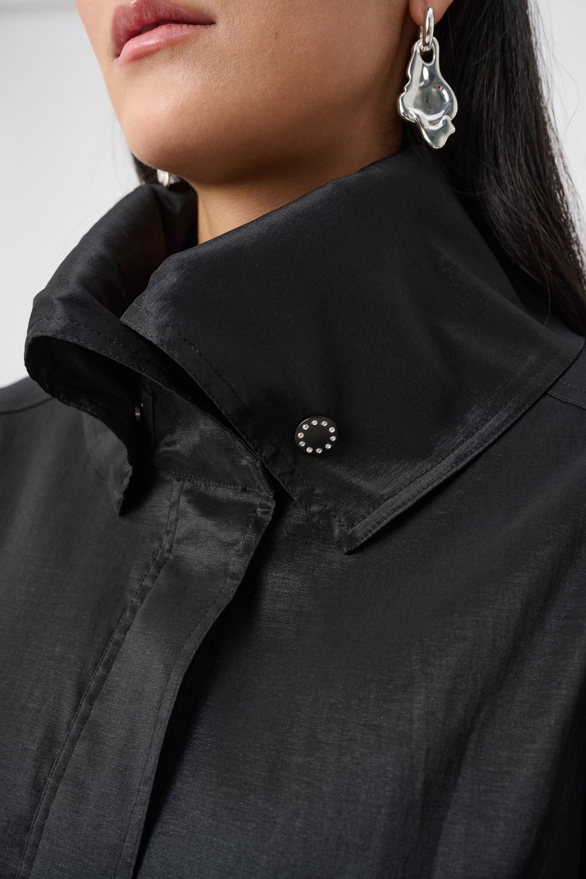 Close-up of collar and fastening details on Joseph Ribkoff Stretch Taffeta Belted Fit & Flare Balloon Coat in Black, style 263911