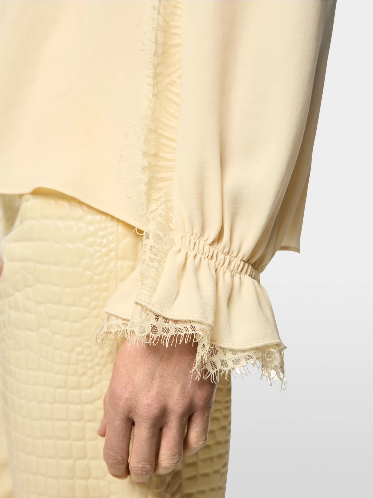 Close-up of lace trim on Marc Cain blouse beige 